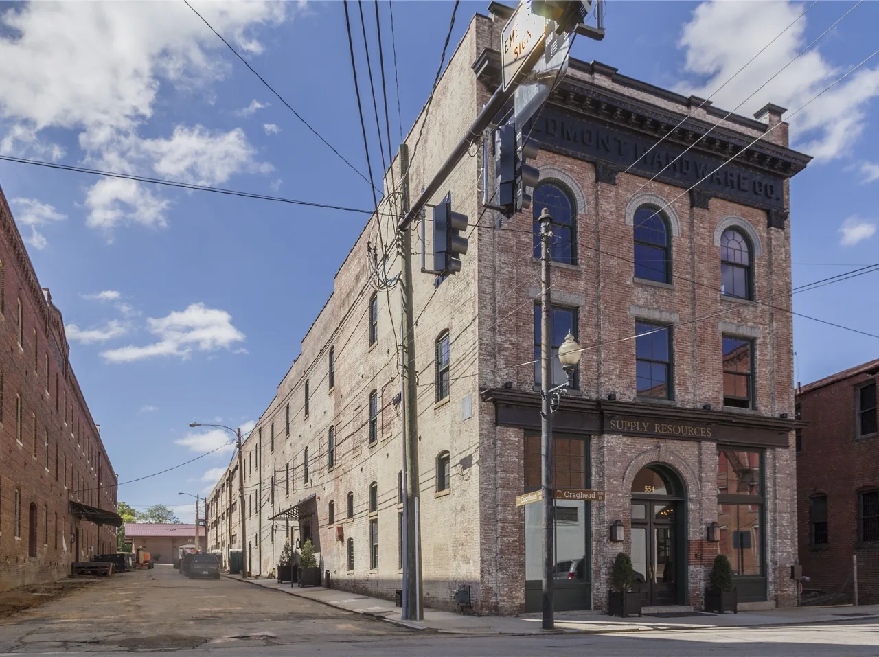 A restored brick warehouse on Craghead Street in Danville's River District — arched windows, a ghost sign and a street lamp at the corner.