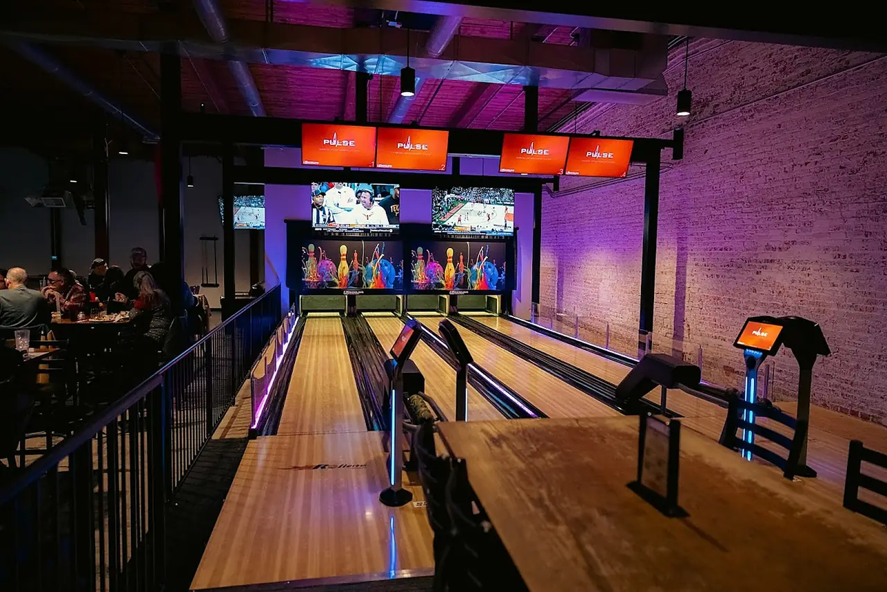 Bowling lanes under LED lighting at River District Social, in Suites A–D of 680 Lynn Street.