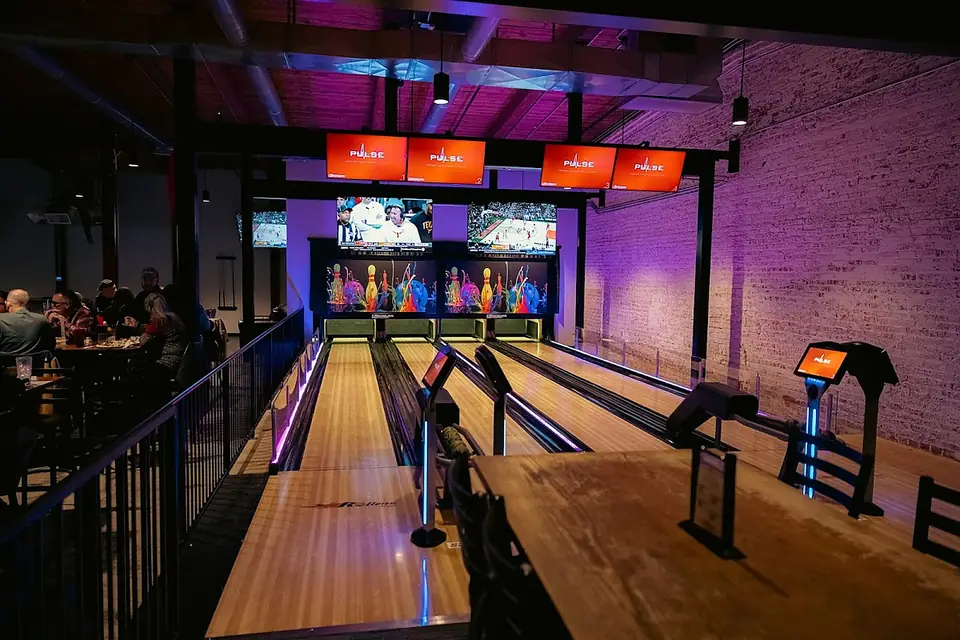 River District Social — the sports and entertainment venue at 680 Lynn Street, with bowling lanes under LED lighting.