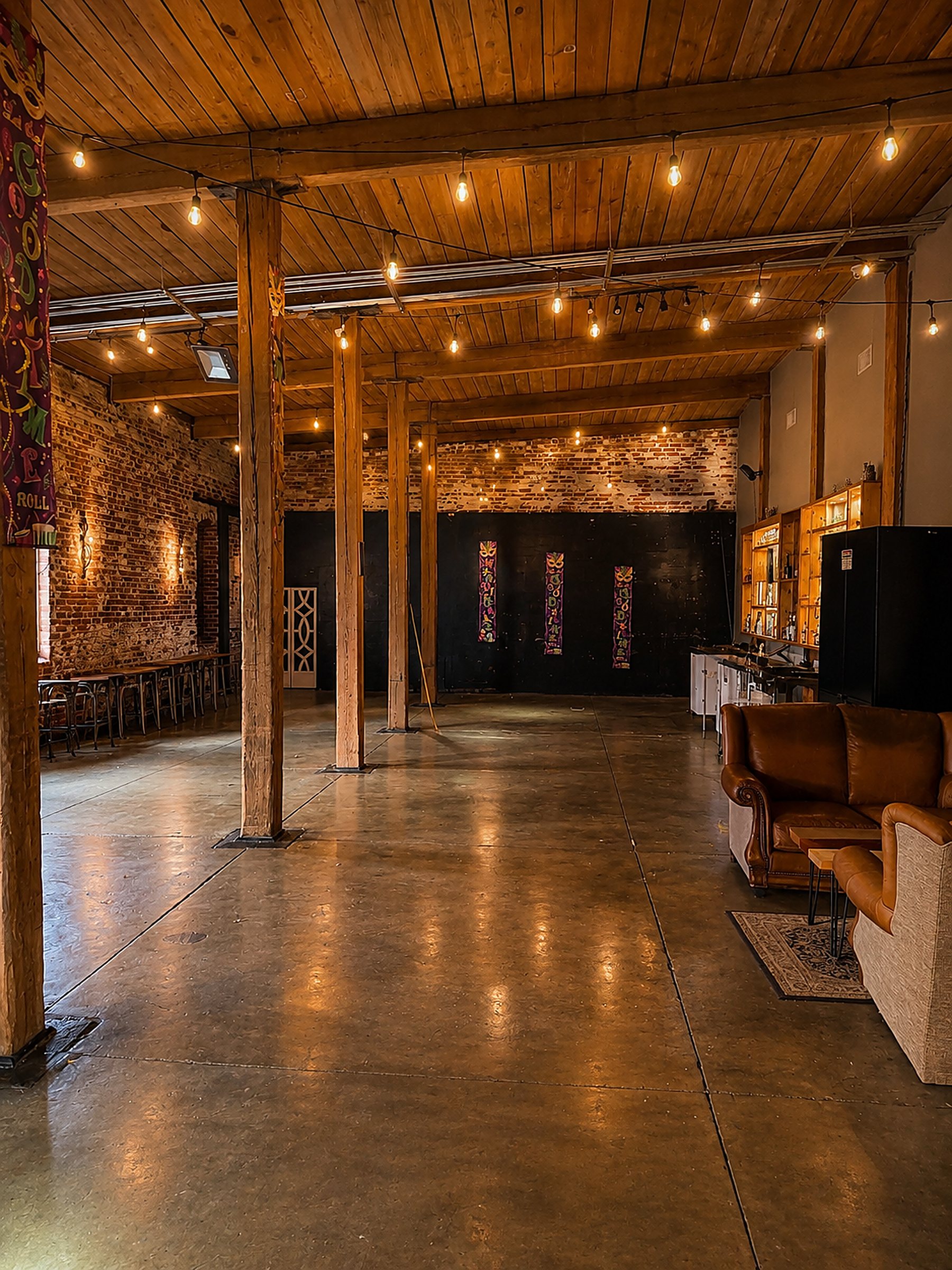 Suite G event lounge at dusk with string lights and leather seating